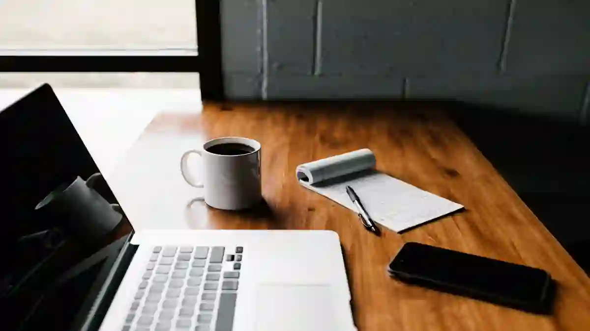 Laptop and notebook on a wooden desk